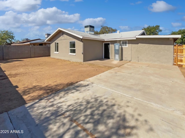 rear view of house with a patio and a fenced backyard