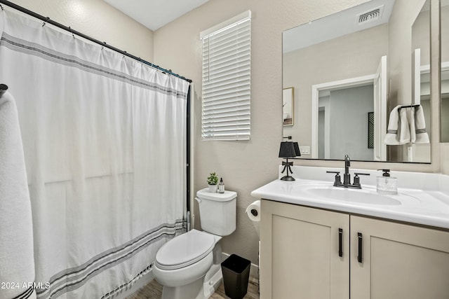 bathroom featuring a shower with shower curtain, vanity, and toilet