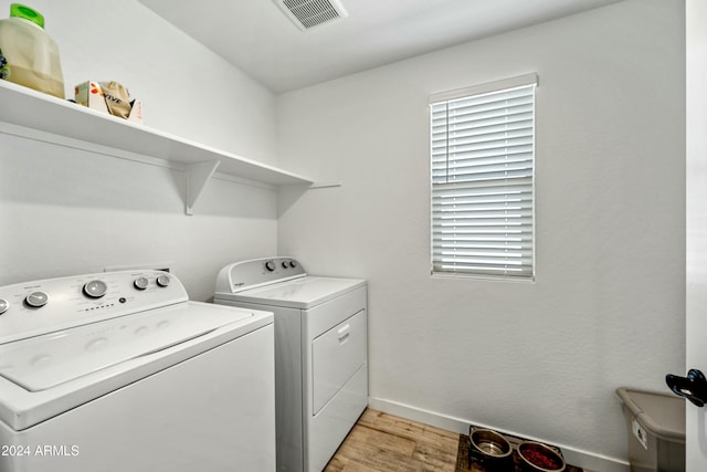 washroom with separate washer and dryer and light hardwood / wood-style flooring