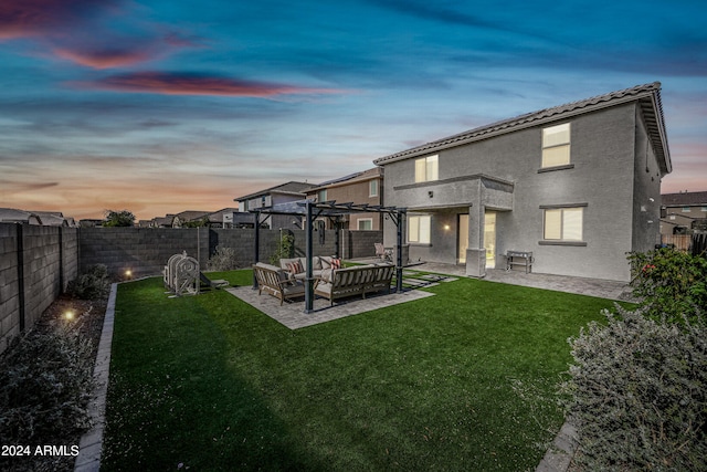 back house at dusk featuring a lawn, a pergola, a patio area, and an outdoor hangout area