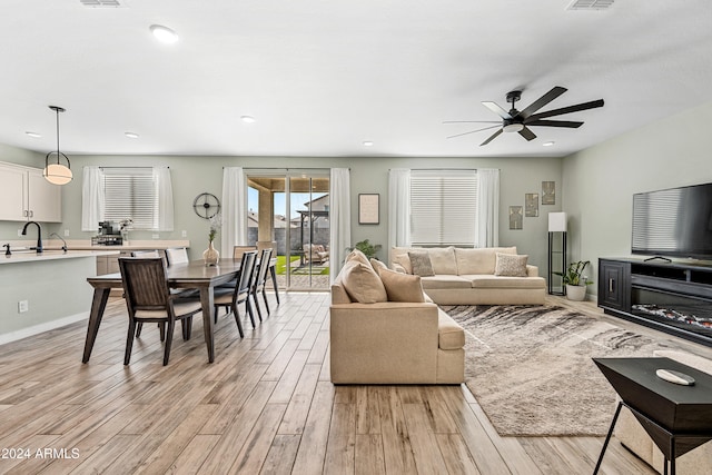 living room featuring ceiling fan and light hardwood / wood-style flooring