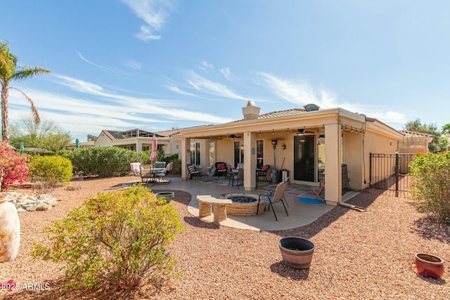 back of house featuring a fire pit, a patio, ceiling fan, fence, and stucco siding