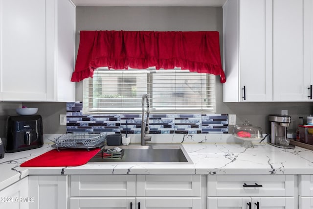 kitchen featuring white cabinets and sink