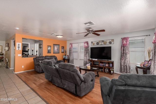 living room featuring light wood-type flooring, ceiling fan, and a healthy amount of sunlight