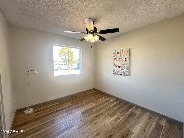 empty room with ceiling fan, hardwood / wood-style floors, and a textured ceiling