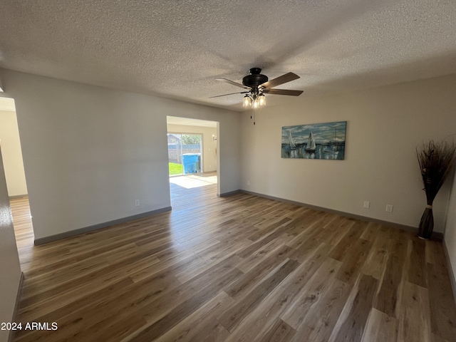 spare room featuring ceiling fan, dark hardwood / wood-style flooring, and a textured ceiling