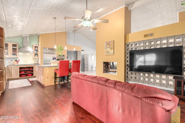 living room featuring dark hardwood / wood-style flooring, high vaulted ceiling, and ceiling fan