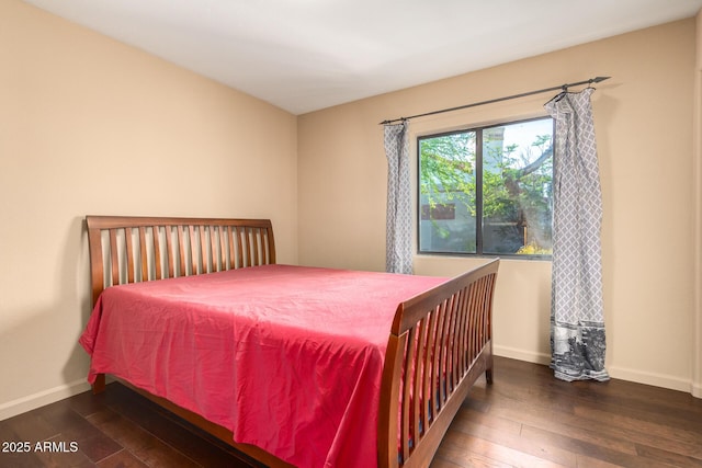 bedroom with dark hardwood / wood-style flooring