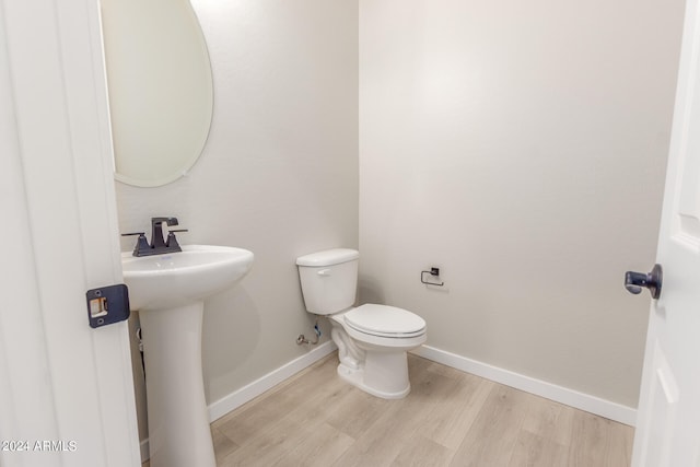 bathroom with toilet and hardwood / wood-style flooring