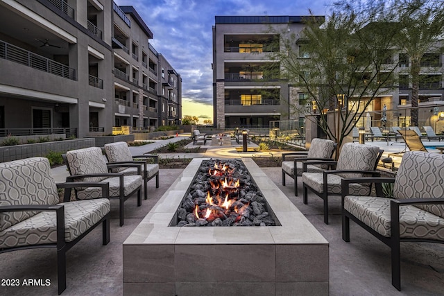 patio terrace at dusk featuring an outdoor living space with a fire pit