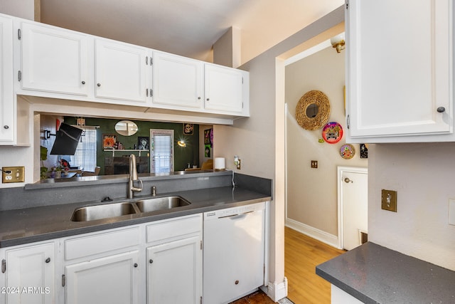 kitchen with sink, white dishwasher, white cabinets, and light hardwood / wood-style flooring