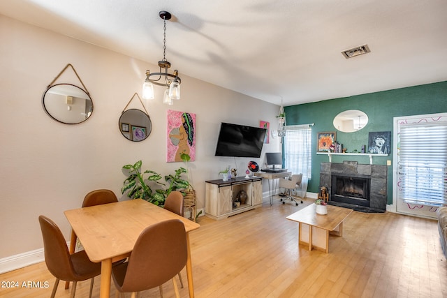 dining area featuring hardwood / wood-style flooring and a tiled fireplace