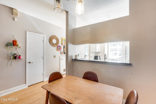 dining space with sink and light hardwood / wood-style floors