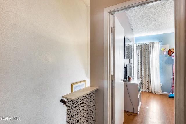 hallway featuring a textured ceiling and light wood-type flooring