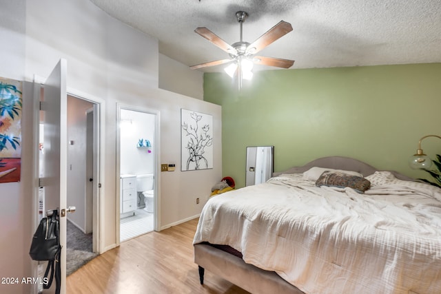 bedroom featuring a textured ceiling, connected bathroom, ceiling fan, and light wood-type flooring