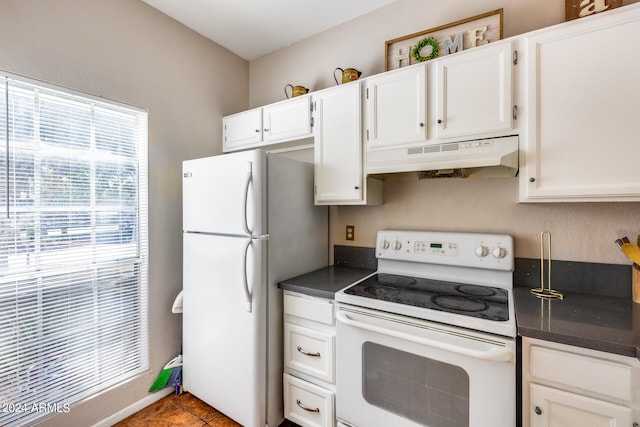 kitchen with white appliances, white cabinets, and tile patterned flooring