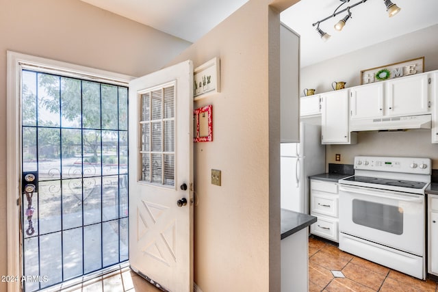 kitchen featuring white appliances, white cabinetry, and light tile patterned floors