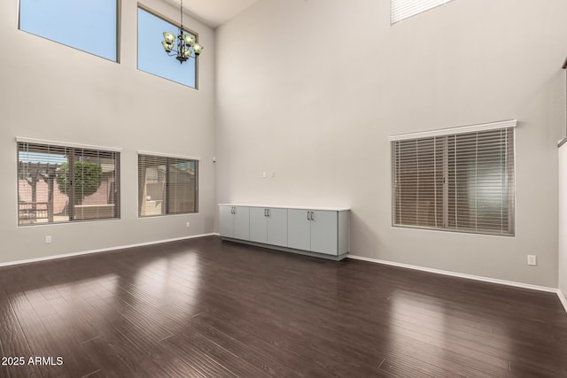 10910 E Sebring Ave, Mesa, AZ 85212 - unfurnished living room featuring a high ceiling, a chandelier, and dark wood finished floors