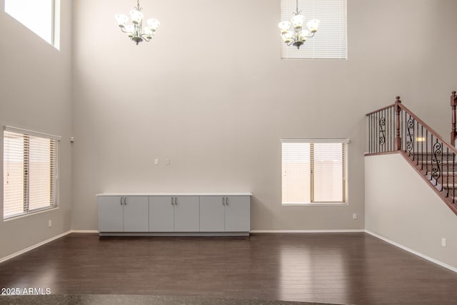 10910 E Sebring Ave, Mesa, AZ 85212 - unfurnished living room featuring a chandelier, a towering ceiling, dark wood finished floors, plenty of natural light, and stairs