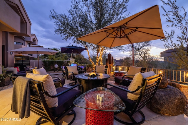 patio terrace at dusk featuring an outdoor living space with a fire pit