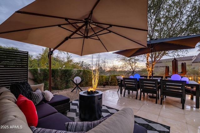 patio terrace at dusk with an outdoor living space with a fire pit