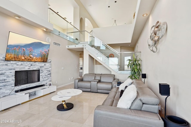 living room featuring a fireplace, a high ceiling, and tile patterned flooring