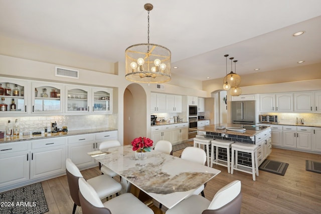 dining space featuring light hardwood / wood-style floors and an inviting chandelier