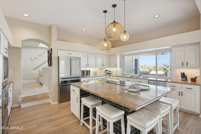 kitchen with white cabinets, a kitchen breakfast bar, and a kitchen island