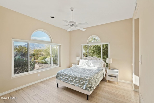 bedroom featuring multiple windows, light hardwood / wood-style flooring, and ceiling fan