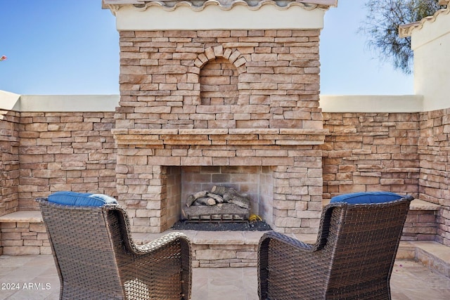 view of patio featuring an outdoor stone fireplace