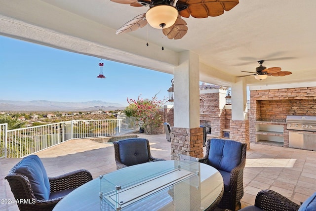 view of patio with area for grilling, a mountain view, and ceiling fan