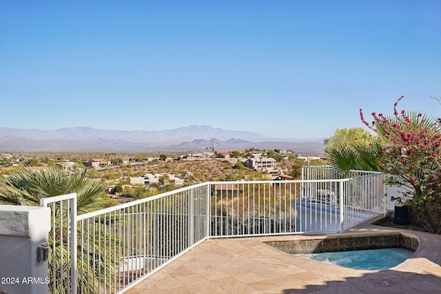 balcony featuring a mountain view and an in ground hot tub