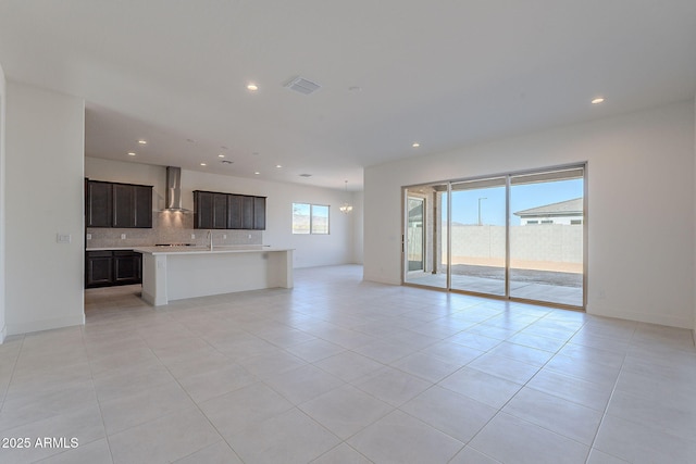 unfurnished living room featuring a notable chandelier and light tile patterned flooring