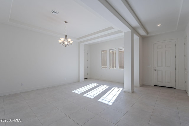 tiled empty room featuring a chandelier and a tray ceiling