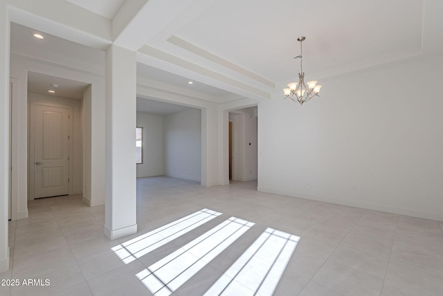 tiled empty room featuring a raised ceiling and a notable chandelier