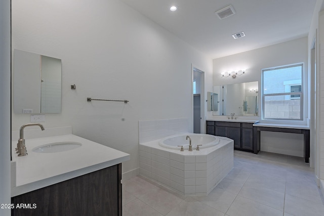 bathroom featuring vanity, tile patterned flooring, and tiled tub