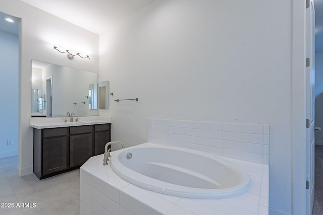 bathroom with tile patterned flooring, a relaxing tiled tub, and vanity