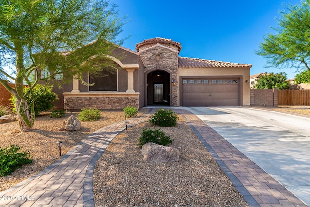 10542 W Electra Ln, Peoria, AZ 85383 - mediterranean / spanish-style home with stone siding, driveway, an attached garage, and stucco siding