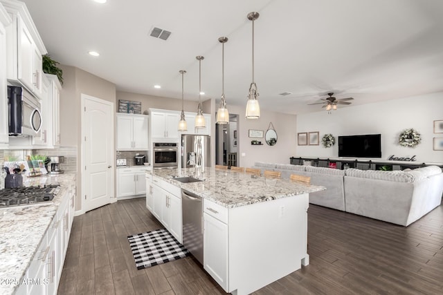 10542 W Electra Ln, Peoria, AZ 85383 - kitchen with stainless steel appliances, a sink, decorative backsplash, a ceiling fan, and dark wood-style flooring