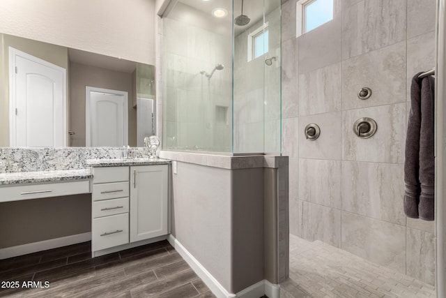 10542 W Electra Ln, Peoria, AZ 85383 - bathroom featuring vanity, a walk in shower, wood finished floors, and baseboards