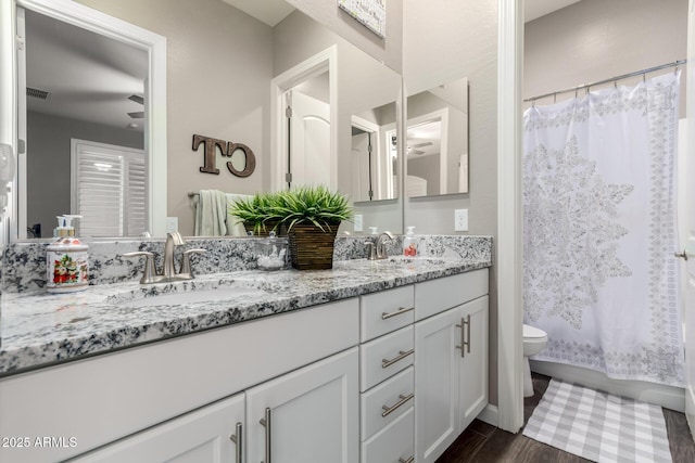 10542 W Electra Ln, Peoria, AZ 85383 - bathroom featuring toilet, double vanity, and wood finished floors