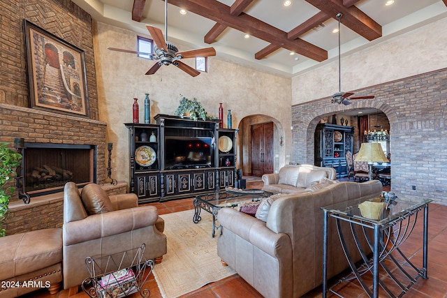 living room featuring a towering ceiling, coffered ceiling, a large fireplace, beam ceiling, and tile patterned flooring