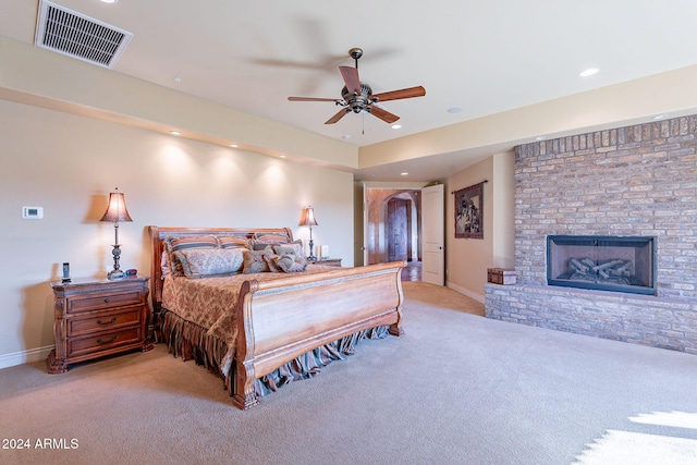 carpeted bedroom featuring ceiling fan and a fireplace