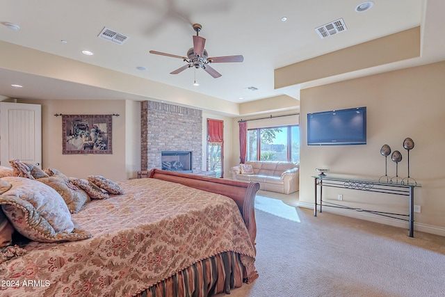 carpeted bedroom featuring ceiling fan and a brick fireplace