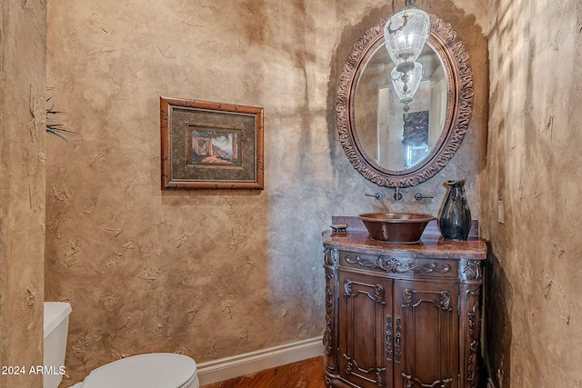 bathroom with hardwood / wood-style floors, vanity, and toilet