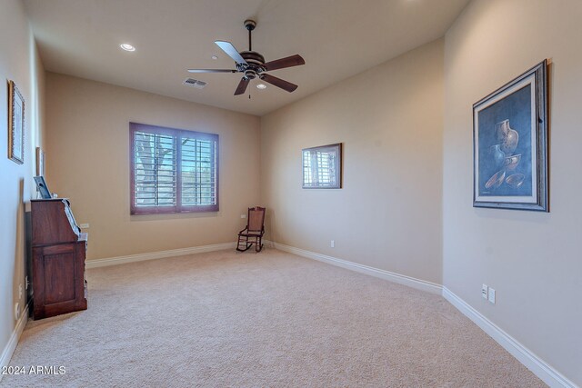 carpeted spare room with ceiling fan