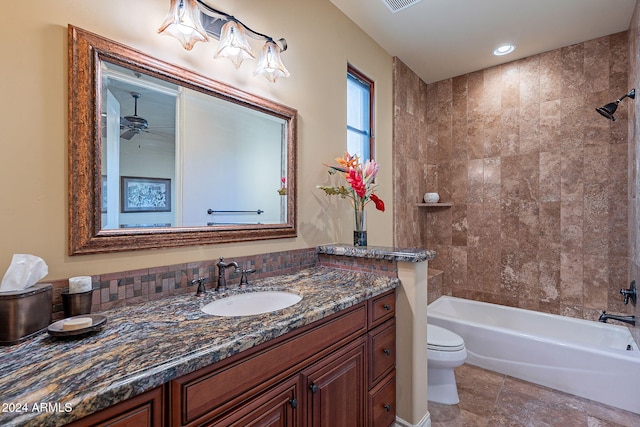 full bathroom featuring ceiling fan, toilet, tiled shower / bath, and vanity