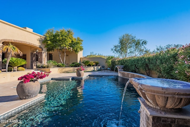 view of swimming pool featuring pool water feature and a patio area