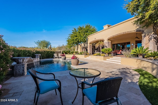 view of pool with pool water feature, ceiling fan, and a patio area