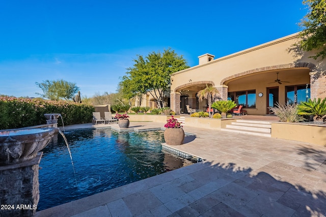 view of pool with pool water feature, ceiling fan, and a patio area